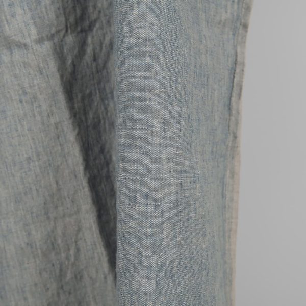 Linen washed fabric grayish blue color for sewing clothes and home textiles close edge view