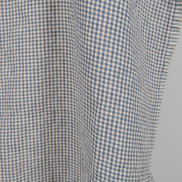 Washed linen fabric with small blue and brownish checks close edge view