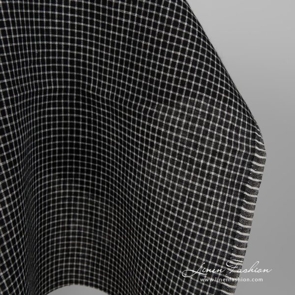 Black linen fabric with white checks close up edge view