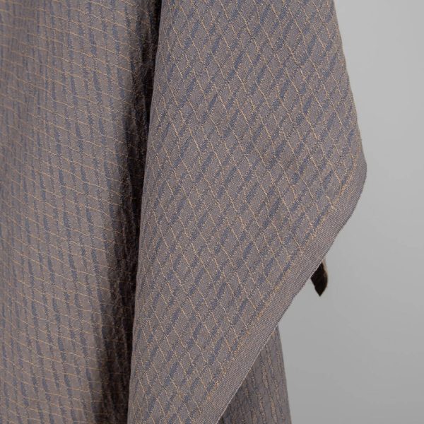 Washed linen cotton fabric blueish grey and brown pattern close up edge view