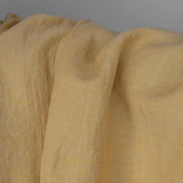 Washed linen cotton fabric in yellow-sand small pattern close up detail