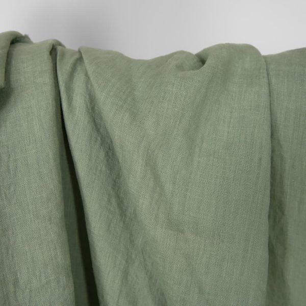 Washed linen fabric in muted light green, plain weave