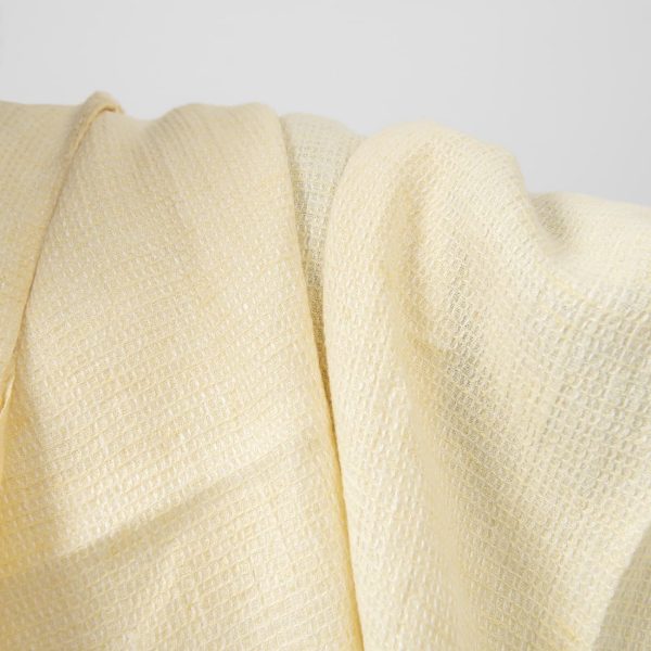 Pale yellow waffle linen fabric washed close up detail