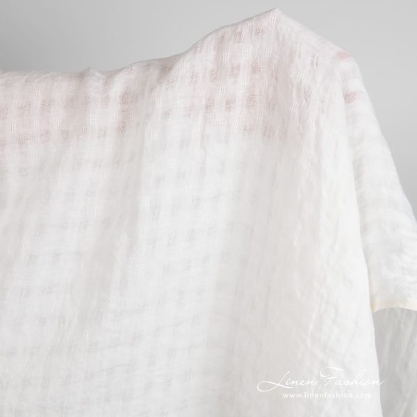 Off-white linen fabric in transparent checks, specially washed to increase softness